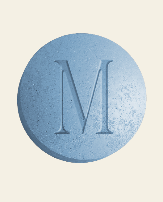 Blue textured round tablet with a large embossed letter M on its surface.