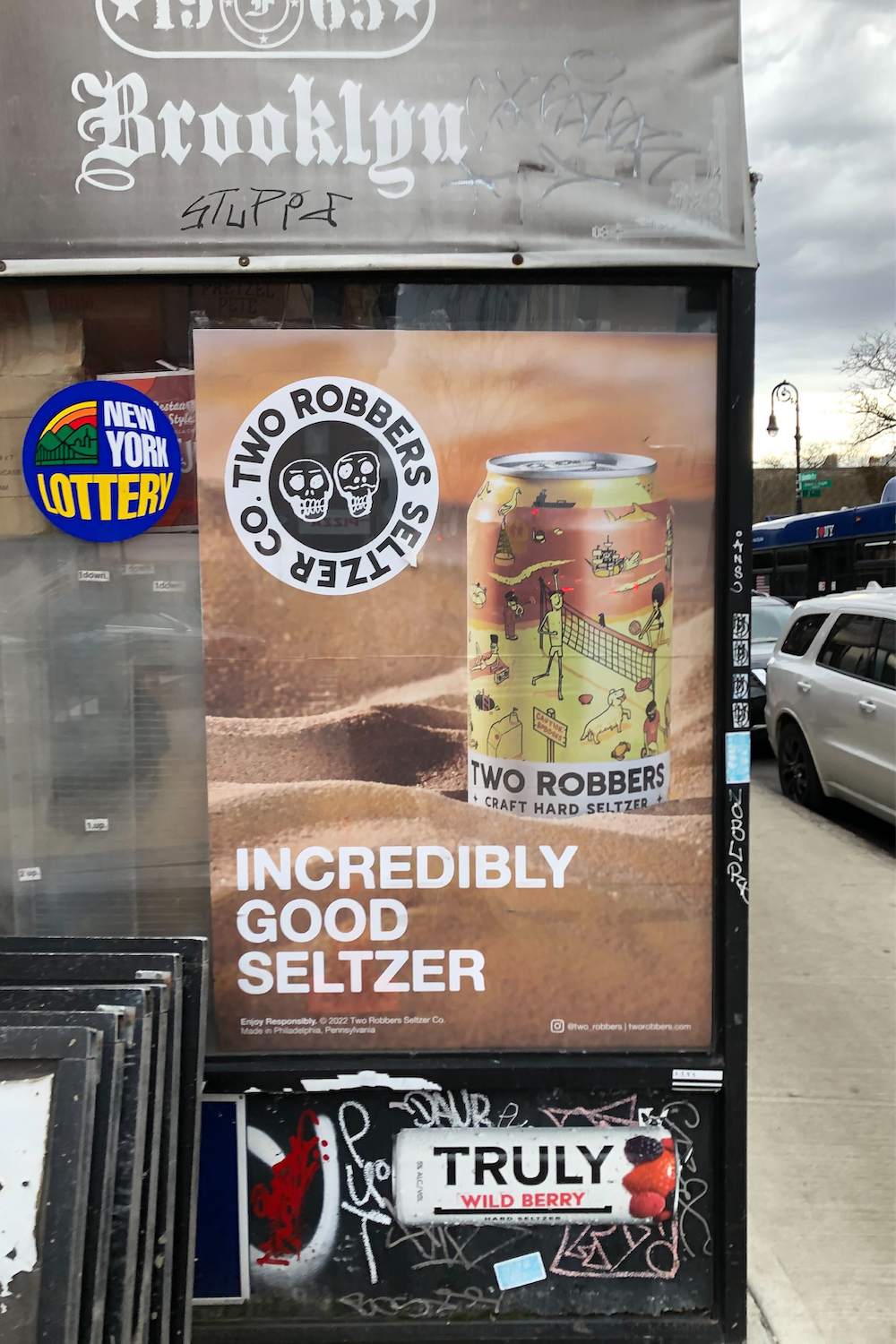 Two Robbers Grapefruit Kiwi poster outside a liquor store.