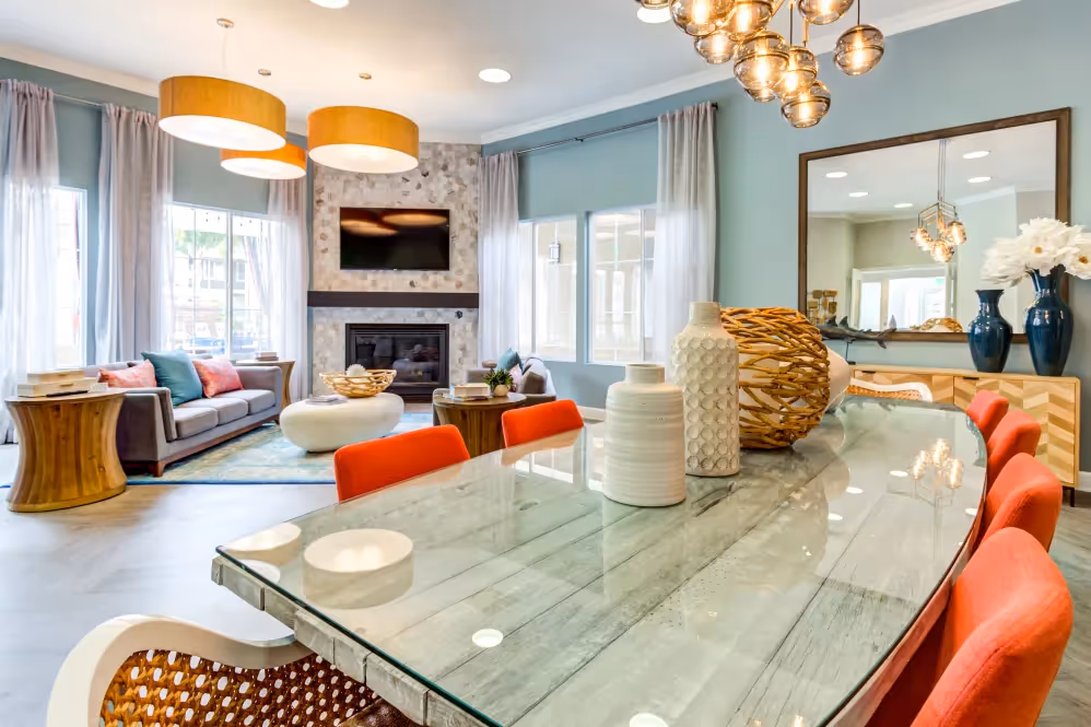 clubhouse seating area with tv, fireplace, and sofa chairs with view of breakfast bar area