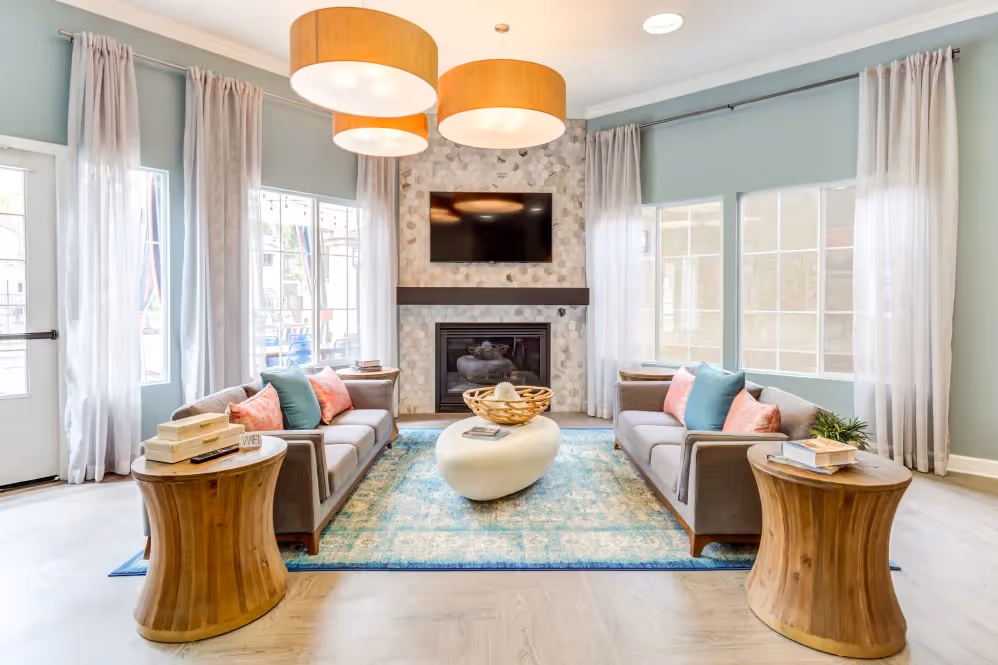 clubhouse seating area with tv, fireplace, and sofa chairs