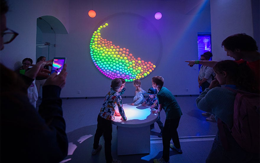 People interacting with 'Signal Playground', a colourful interactive light installation by Christie Digital.