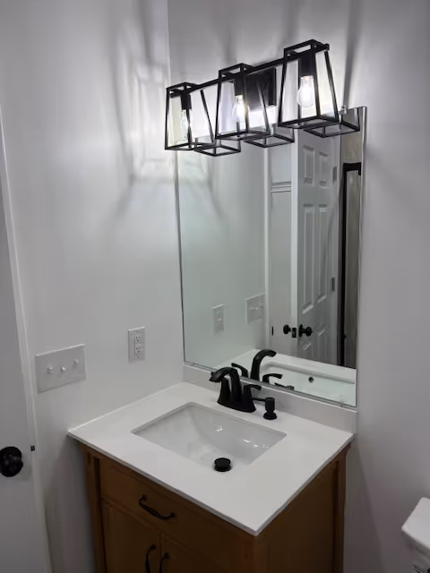 Stainless steel gas stove with black grates and digital clock displaying 9:45 with a black oven mitt hanging on the oven door handle.
