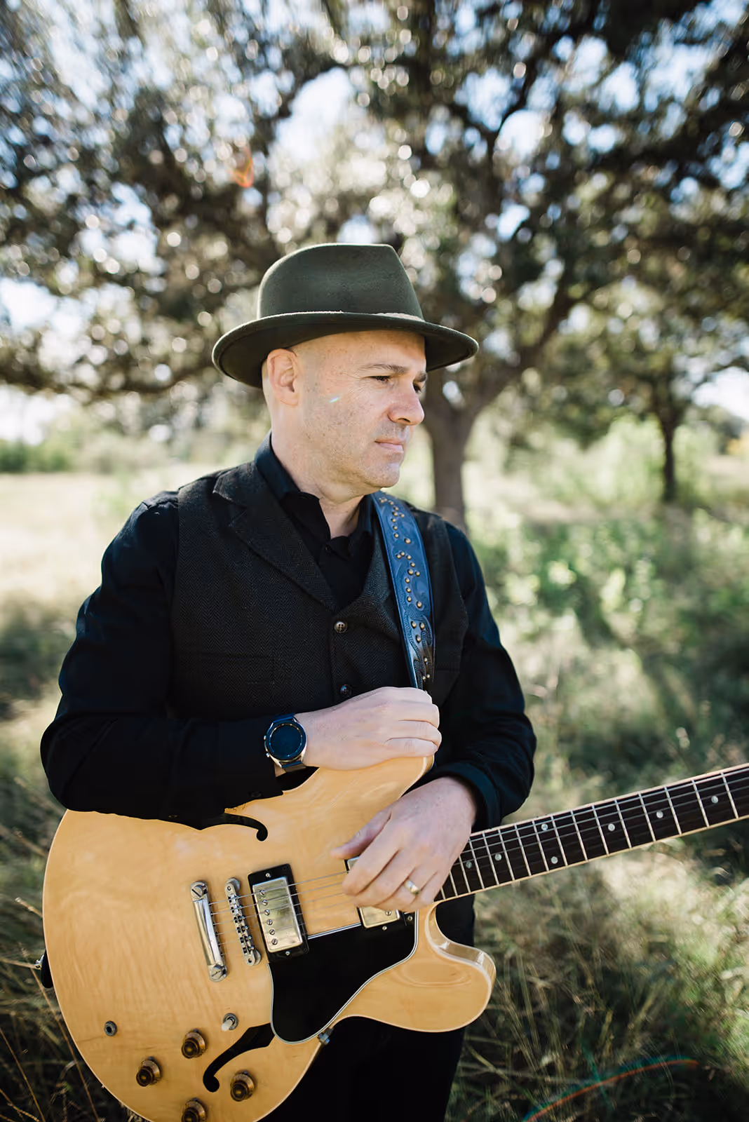 a man in a hat playing a guitar