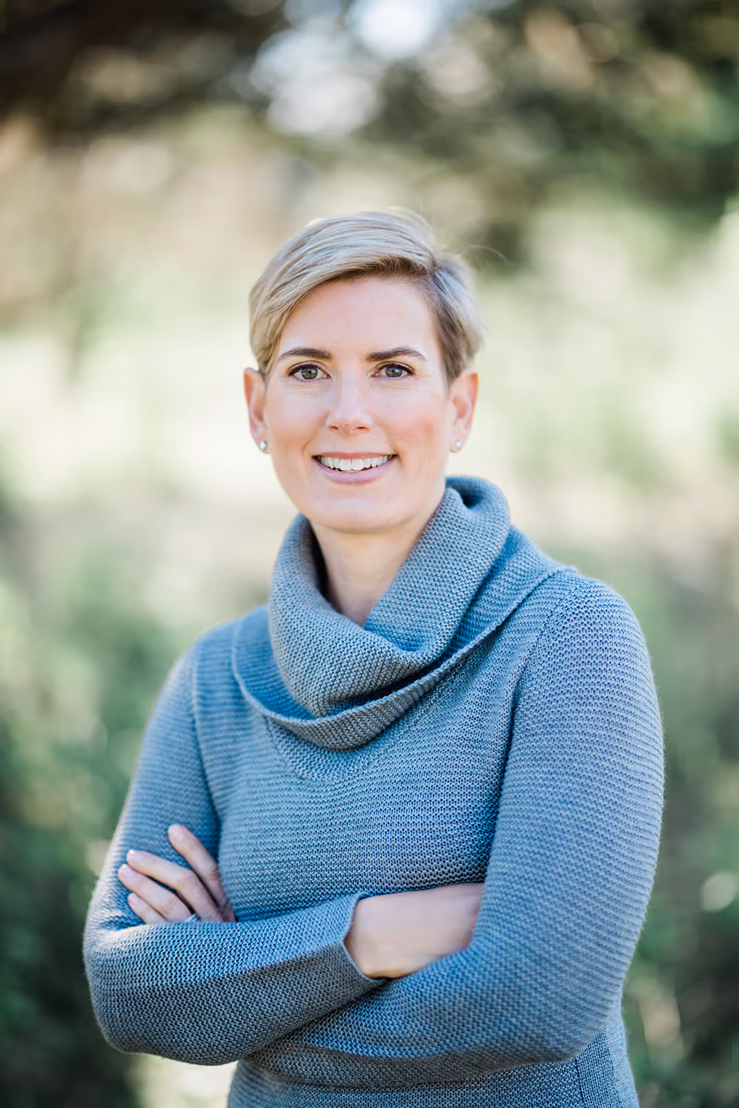 a woman with short hair wearing a blue sweater