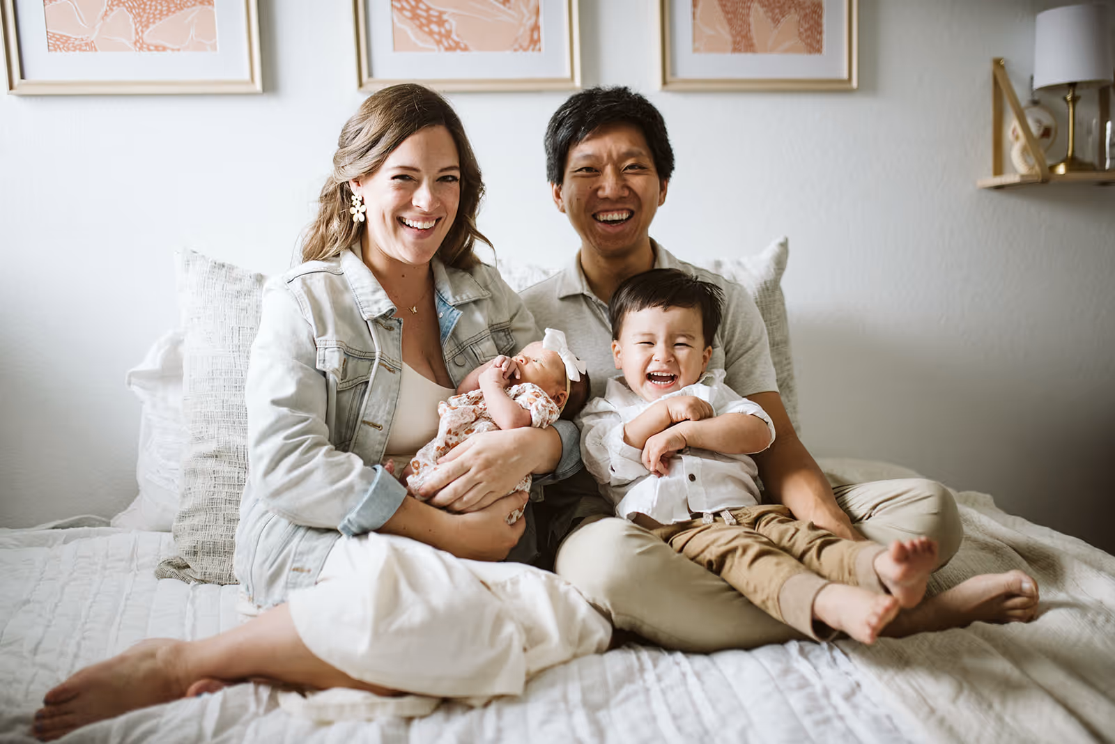 a man and woman sitting on a bed with a baby and a baby