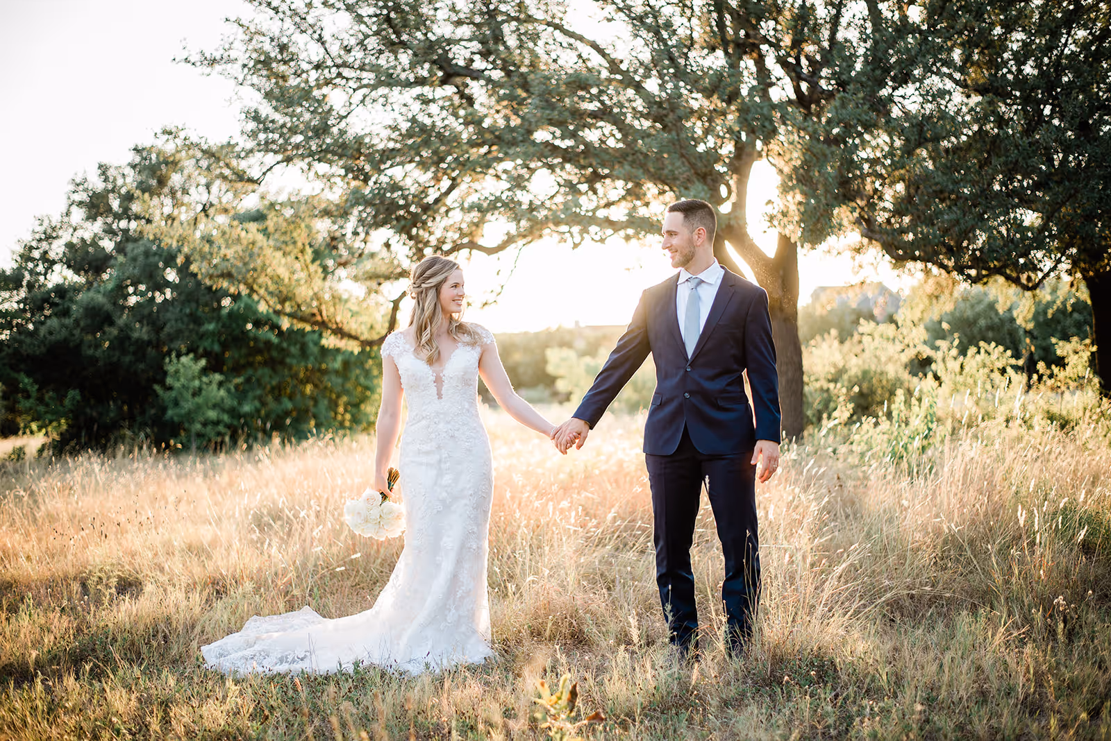 a man and woman holding hands in a field