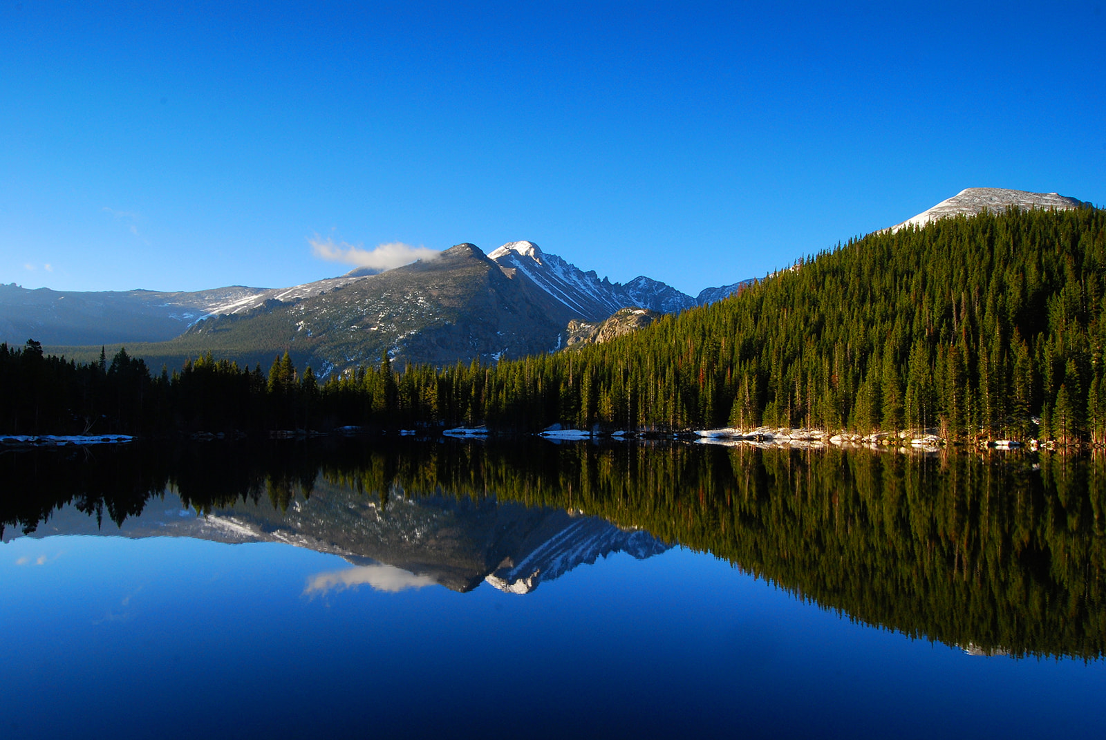 a lake with trees and mountains in the background
