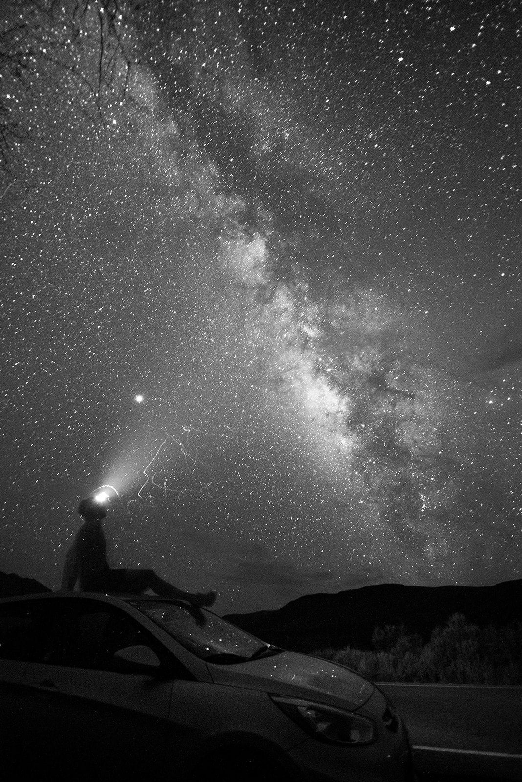 a person sitting on a car with a headlamp