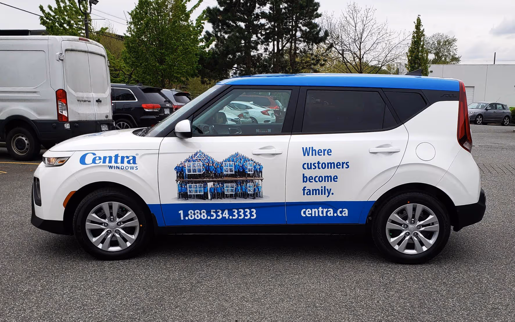 White and blue Centra Windows branded car with a group photo forming house shapes and text reading 'Where customers become family.'