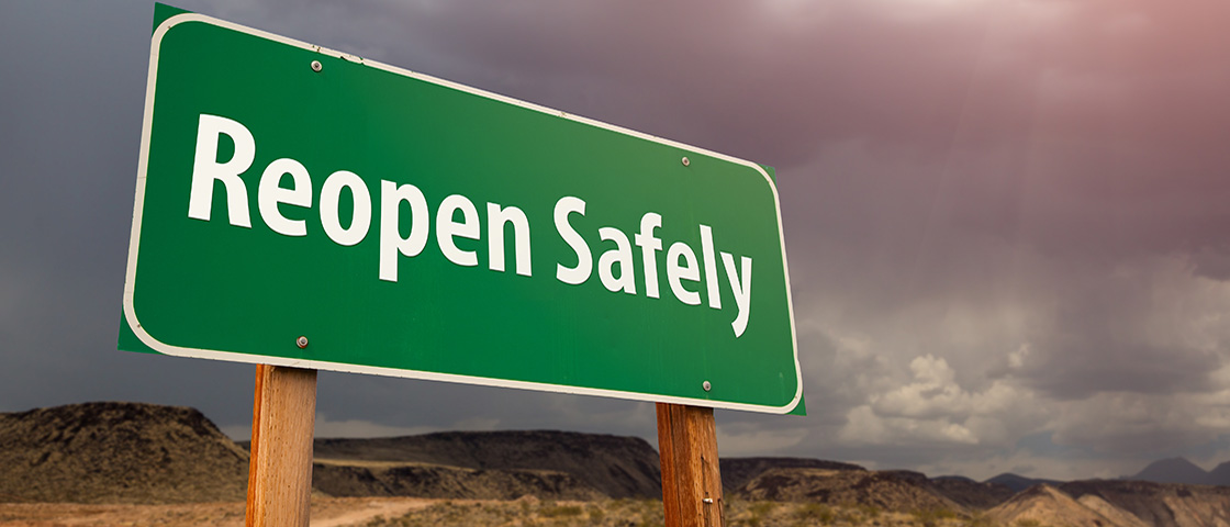 Green road sign reading “Reopen Safely,” symbolizing guidance for safely reopening school buildings.
