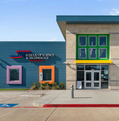 Front of a modern school building with colorful window frames. The sign reads "School of Science & Technology." Clear sky, bright and inviting atmosphere.