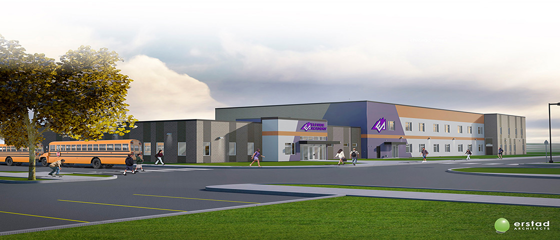 A modern school building with a flat roof, large windows, and a purple sign. A yellow school bus and people walking are seen outside on a paved driveway.