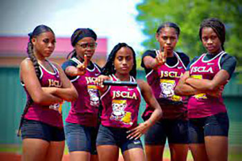 Five female track athletes in maroon uniforms pose confidently on a track. Each has serious expressions, signifying strength and teamwork.