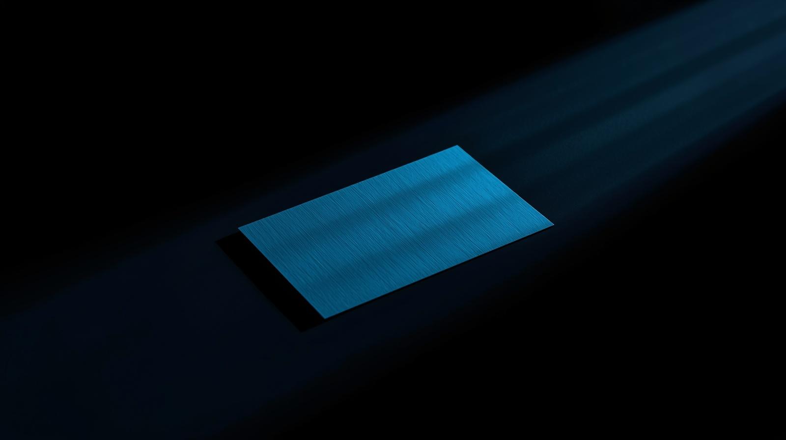 Laptop with dark screen illuminated by blue light rays on a black background.