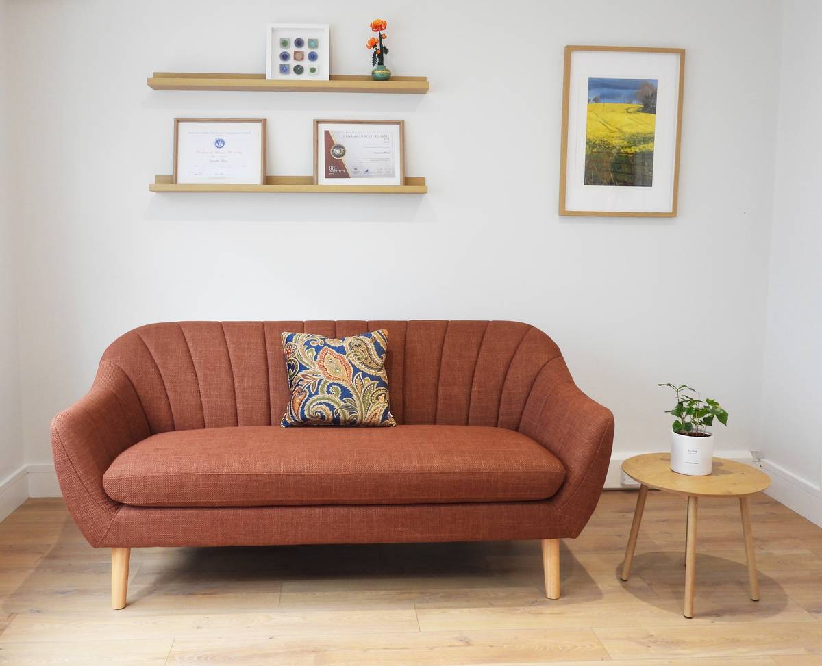 The waiting area at Kenmare Foot Clinic, with a sofa and framed professional certificates on the wall.