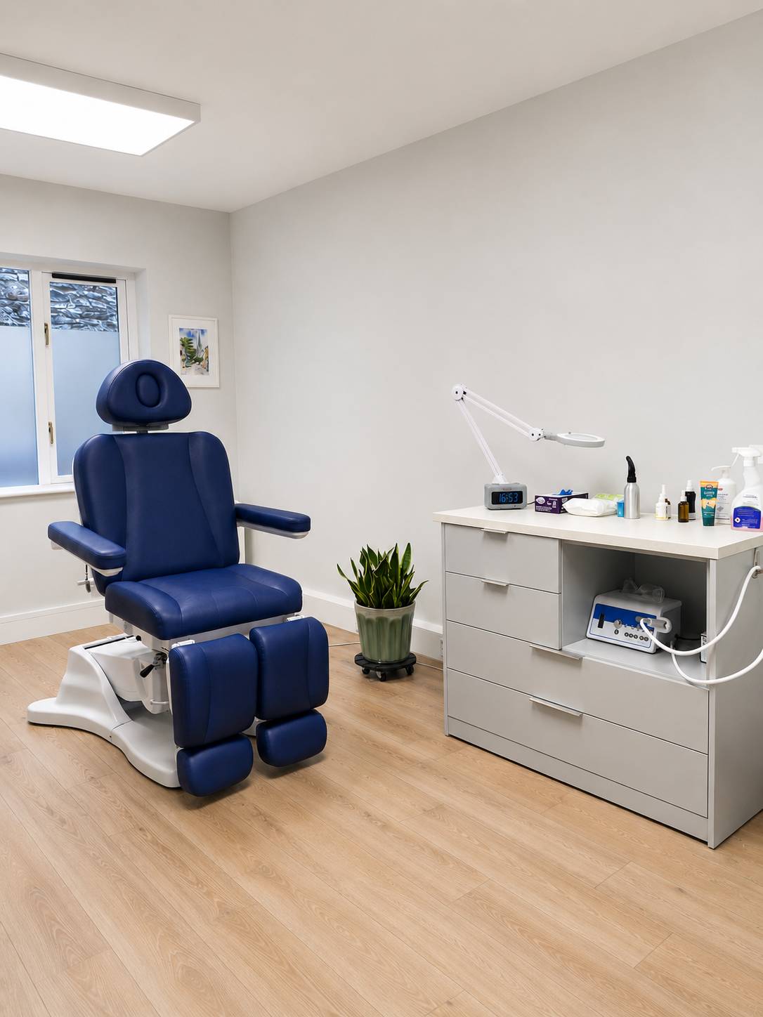 The treatment room at Kenmare Foot Clinic, with a blue reclining treatment chair and clinical equipment.