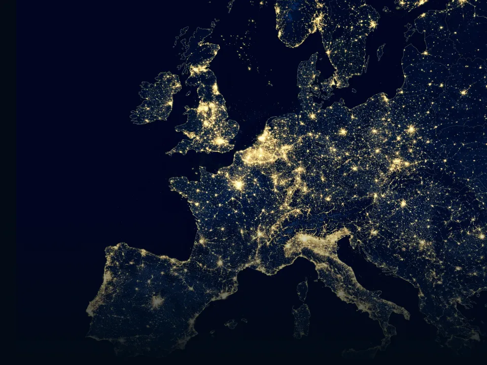 Satellite view of Europe at night showing illuminated cities and populated areas.