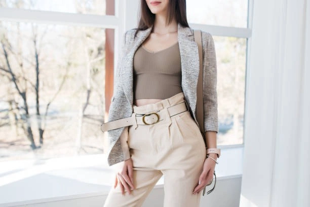 Woman wearing a tweed blazer and cream trousers over a casual brown top, demonstrating the 2x2 outfit formula