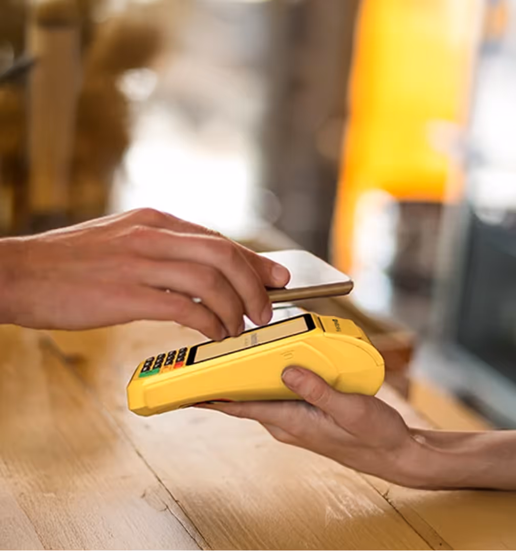 Pessoa fazendo pagamento por aproximação com smartphone em uma maquininha Hillpay Pro.
