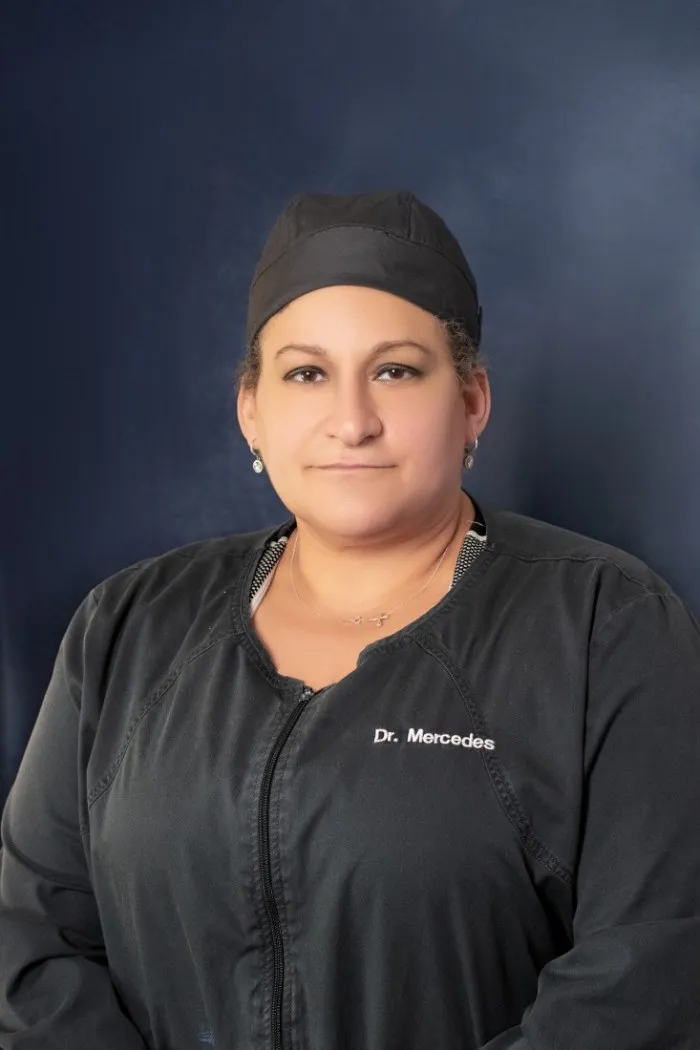 A person is wearing a black uniform with "Dr. Mercedes" embroidered on the chest