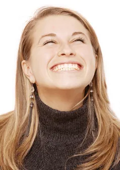 Woman with long hair beams joyfully, looking upwards. 
