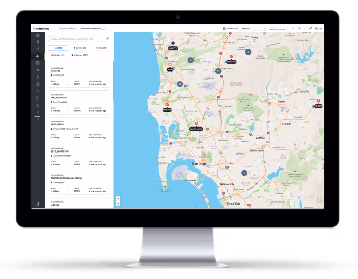 Computer monitor displaying a fleet management interface with a map of the San Diego area showing vehicle locations and statuses.