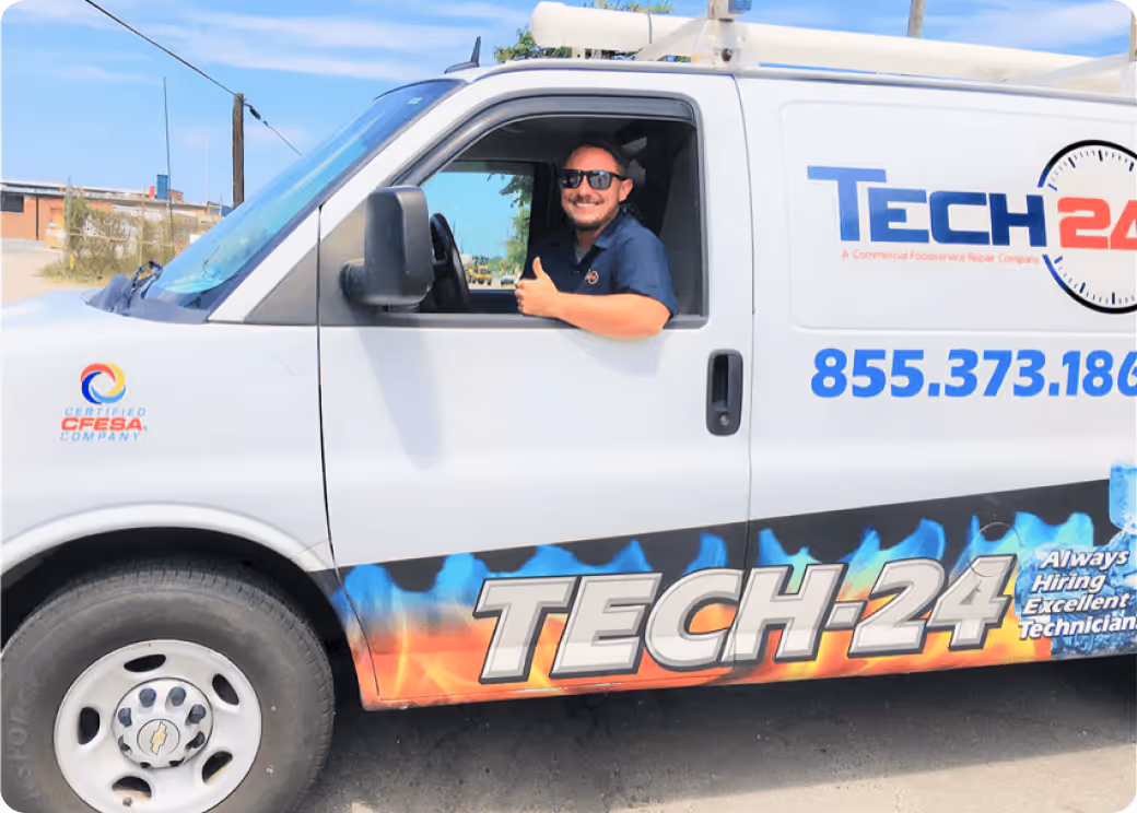 Man in sunglasses smiling and giving thumbs up from driver seat of a Tech-24 service van.