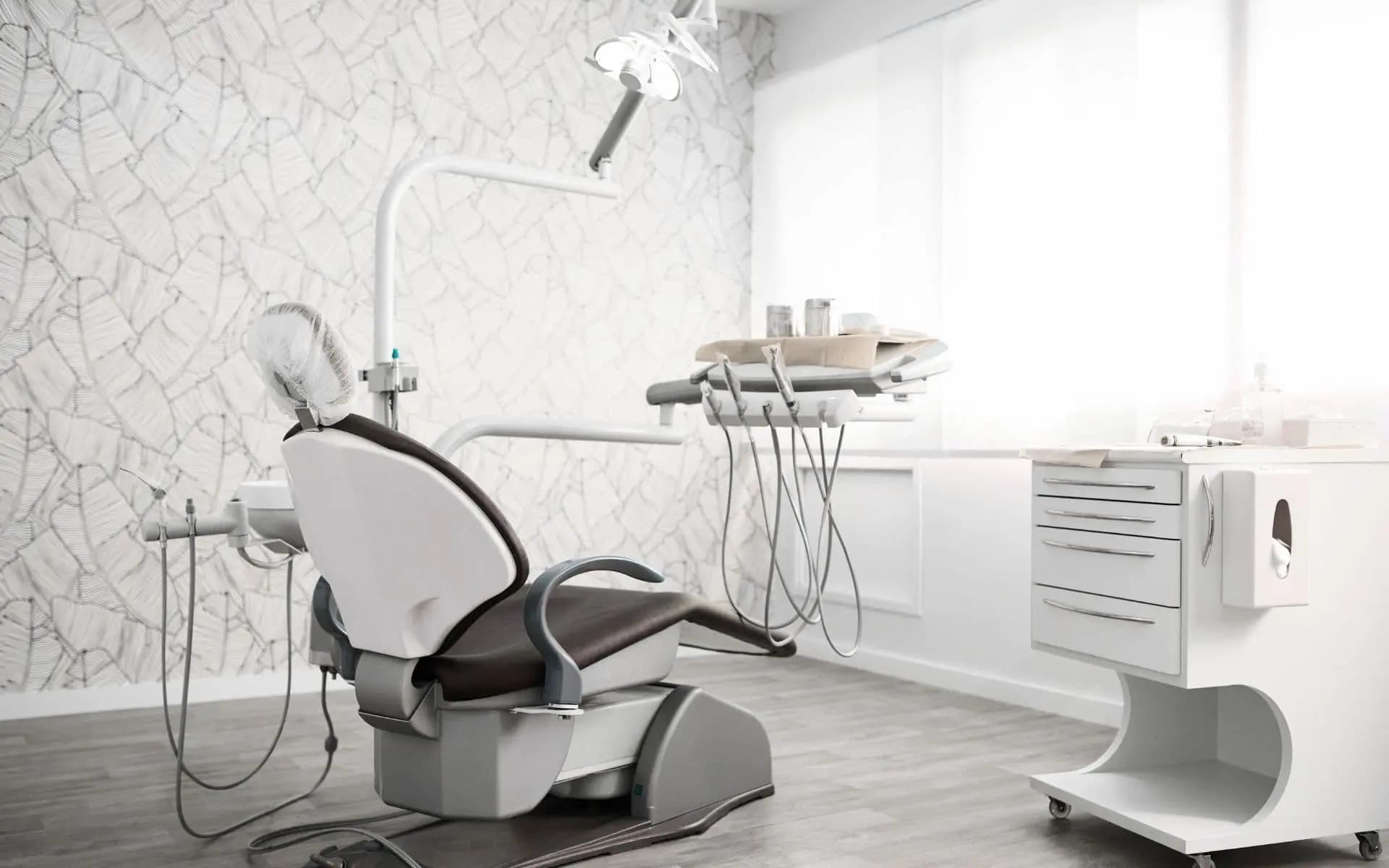 Bright, modern dental treatment room with a reclining chair, overhead light, and instrument tray, ready for a family dentistry visit.