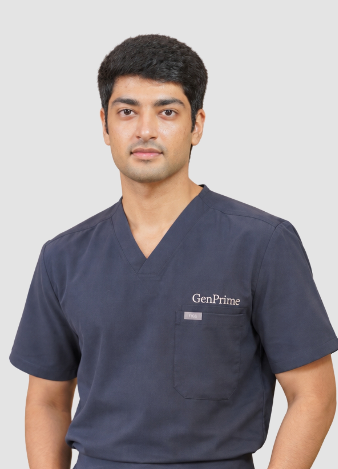 Portrait of a GenPrime junior embryologist wearing navy scrubs against a light grey background.