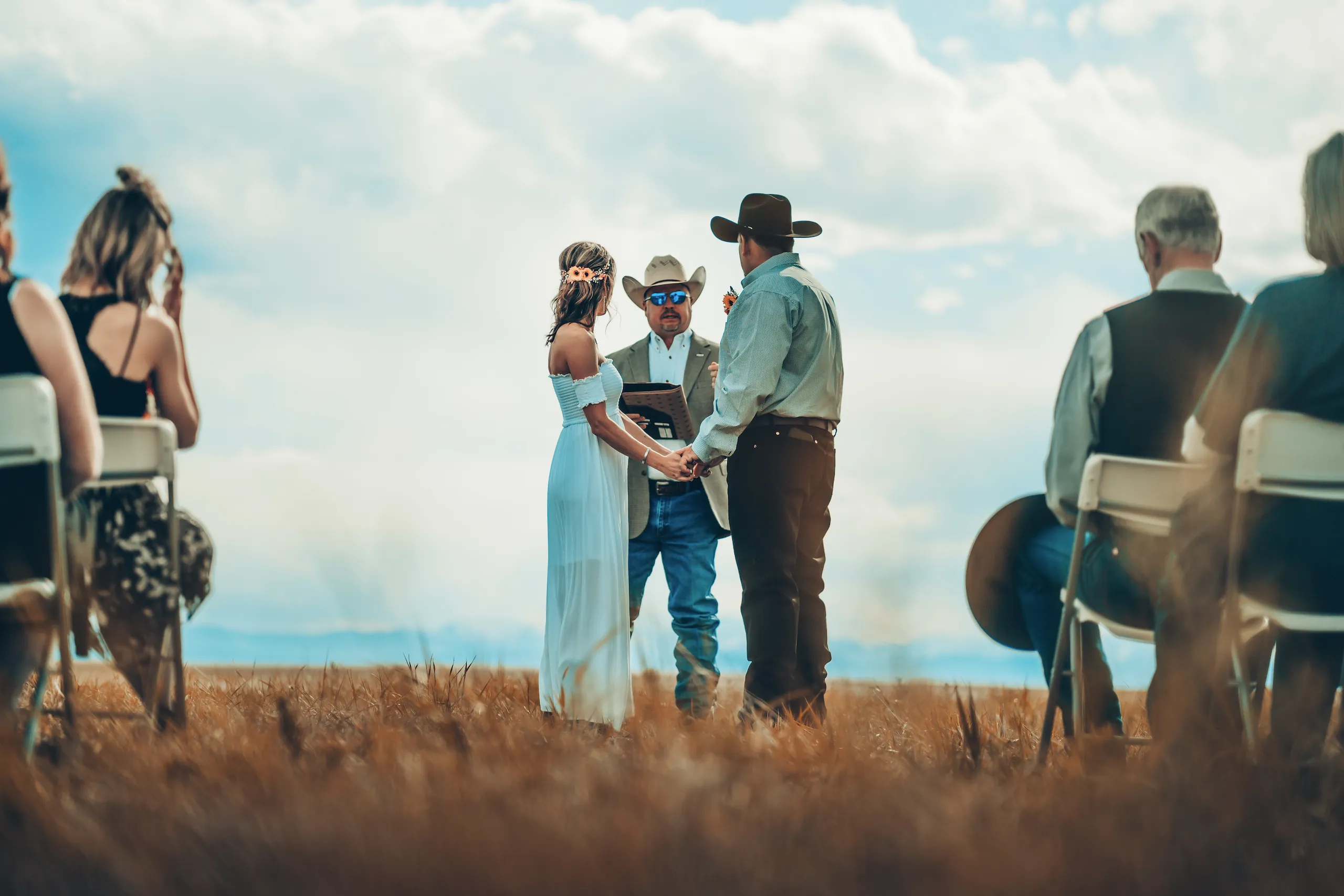 Bride and groom embracing outdoors during a ranch-style wedding ceremony.
