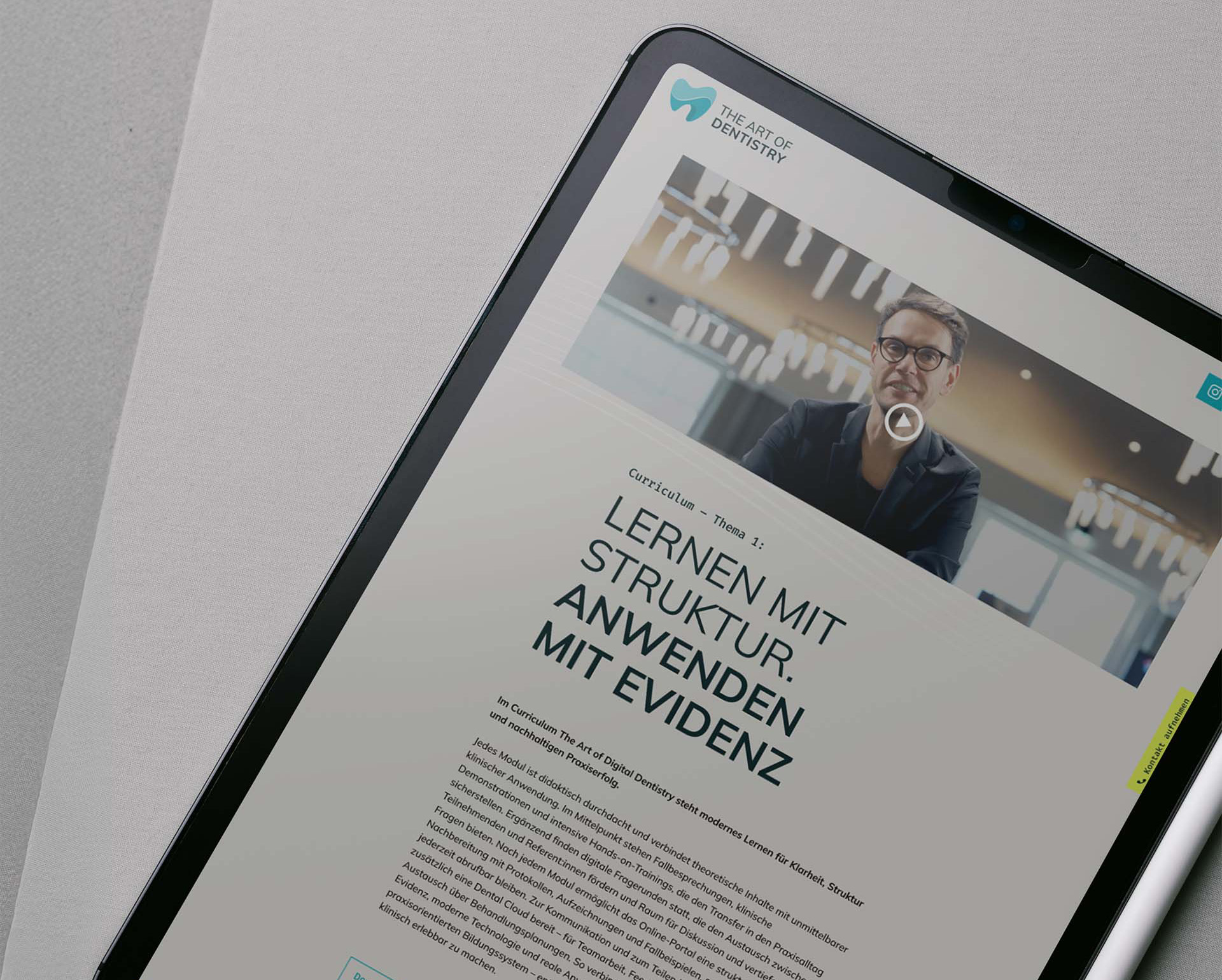 Tablet zeigt eine Website der Zahnmedizin mit dem Titel 'Lernen mit Struktur. Anwenden mit Evidenz' und einem Video von einem Mann mit Brille.