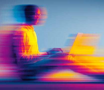 Warme kop koffie in een wit met blauw versierde mok op een houten tafel met croissants, jam, boter, een kom bessen en een krant.