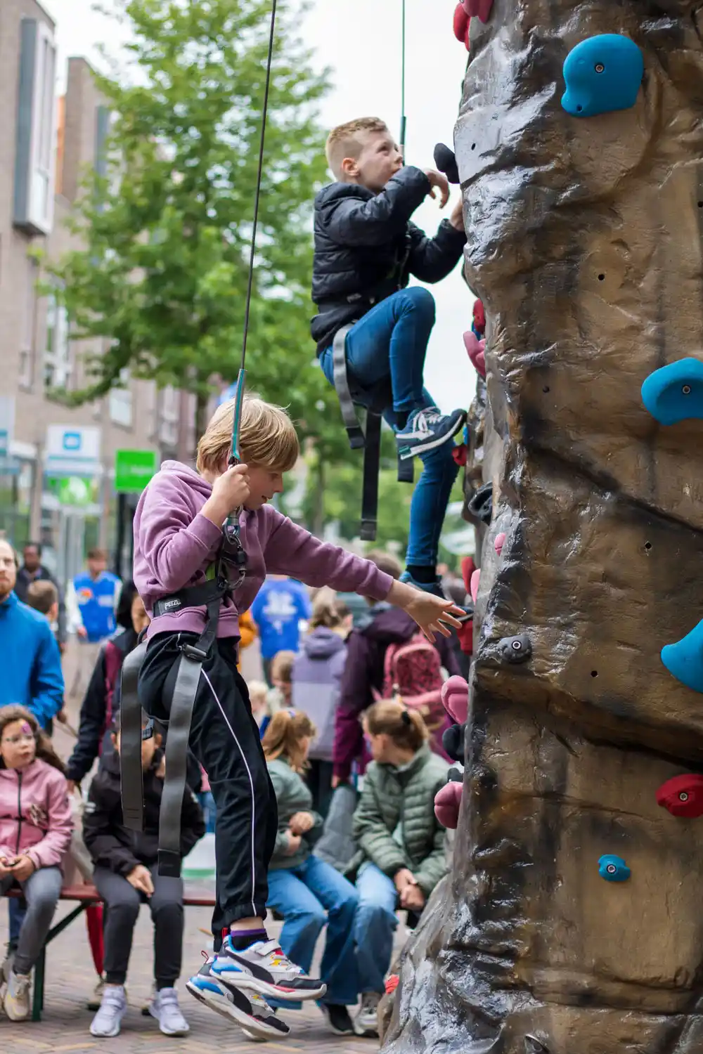 kinderen die klimmen op de mobiele rots tijdens een evenement
