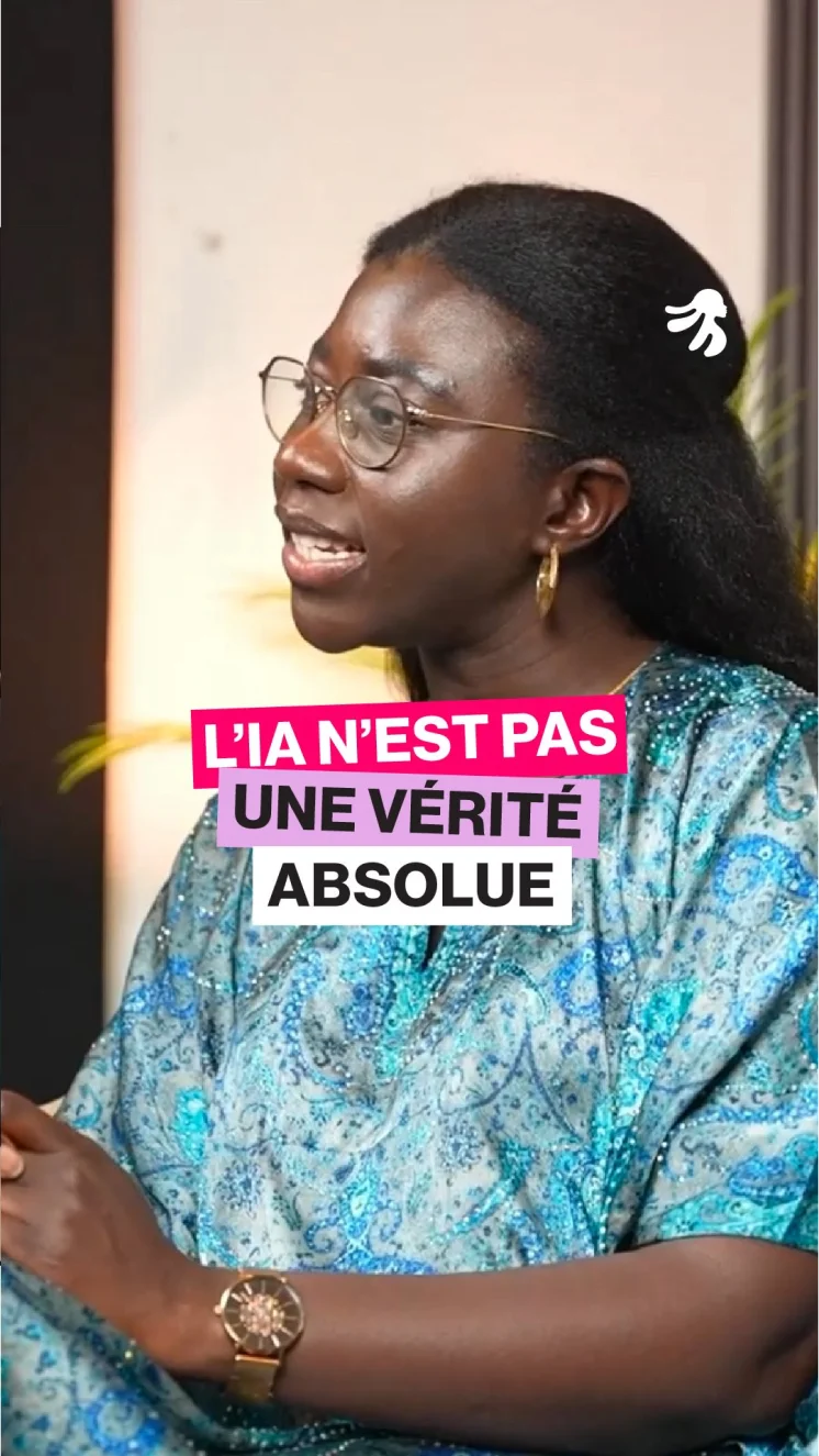 Woman with glasses and gold hoop earrings wearing a blue patterned top, speaking, with French text overlay saying 'L'IA n'est pas une vérité absolue.'