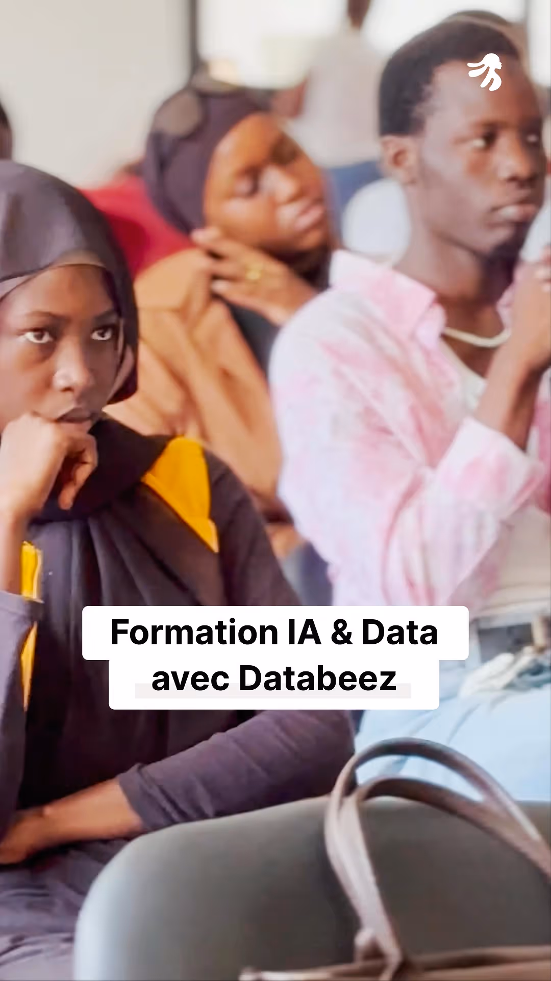 Group of young adults listening attentively during an AI and data training session.