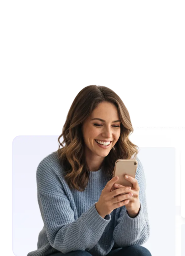 Smiling woman in a blue sweater looking at her smartphone.