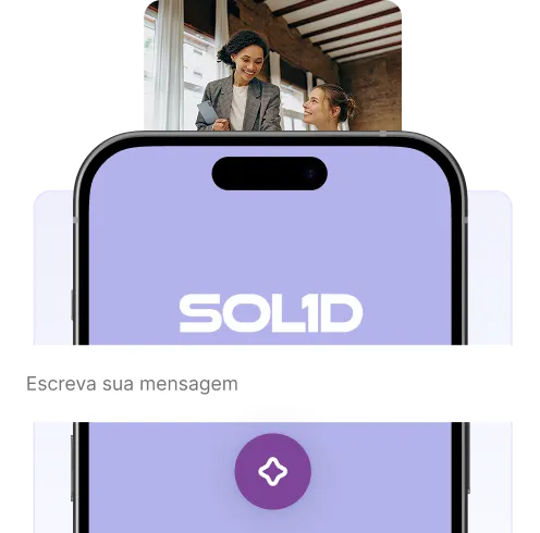 Two women smiling and talking in a bright office setting behind a smartphone displaying a purple screen with the word SOL1D and a text input bar in Portuguese.
