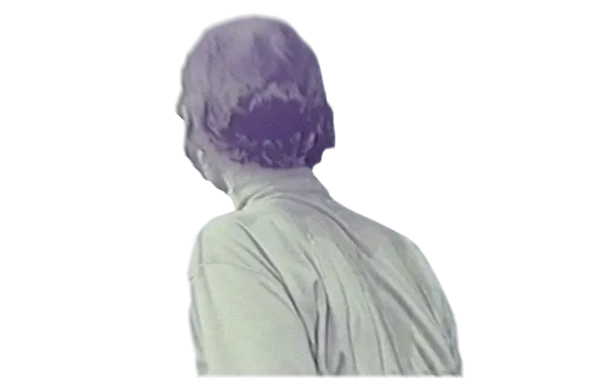 Rear view of a person with short, wavy hair wearing a light-colored shirt.