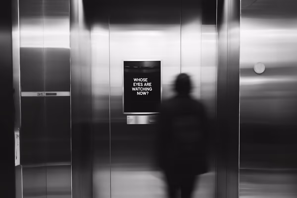 Blurred silhouette of a person standing in front of a metallic wall with a sign that reads 'WHOSE EYES ARE WATCHING NOW?'