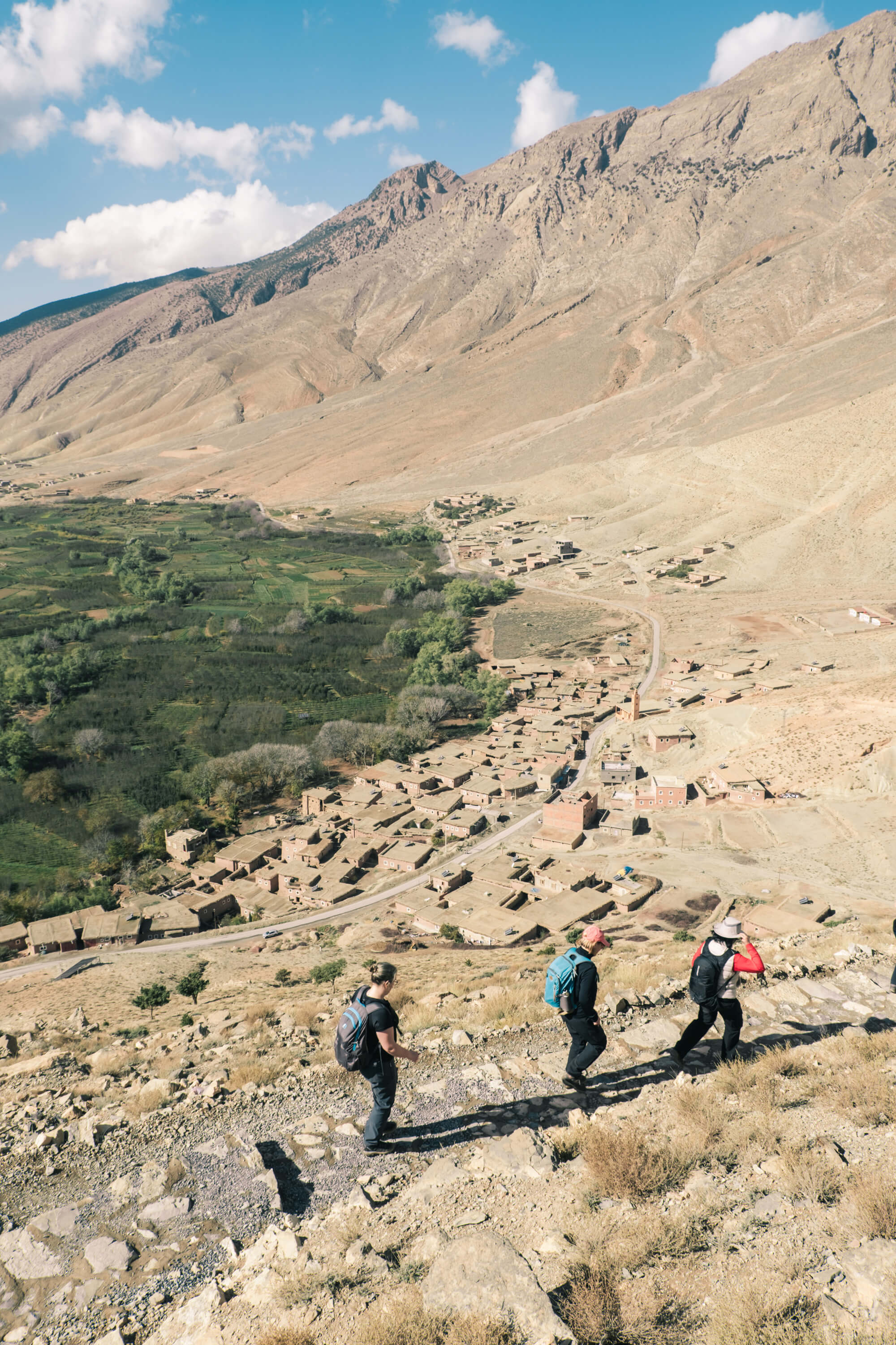 Randonneurs dans la vallée de l'Atlas, village berbère en contrebas dans la vallée ait bougemez