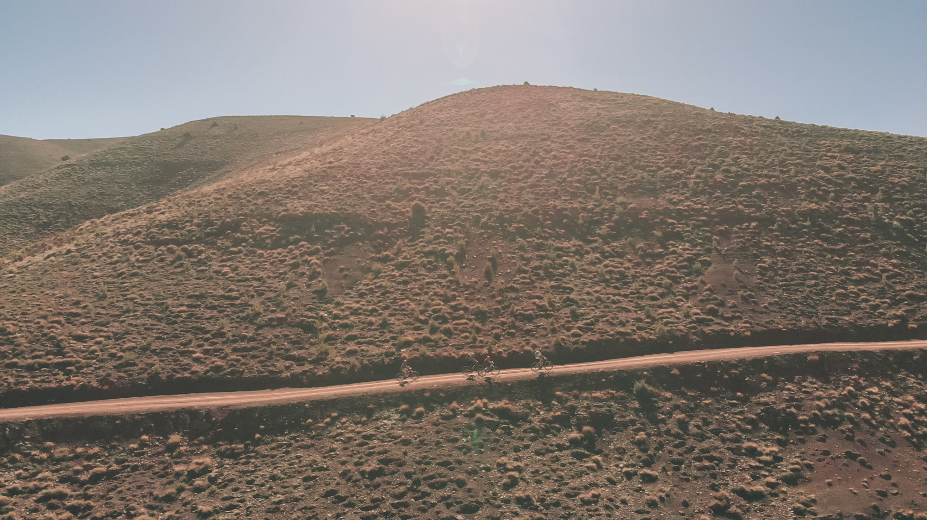 vtt solitaires pédalant sur une route rocailleuse dans l'Atlas marocain