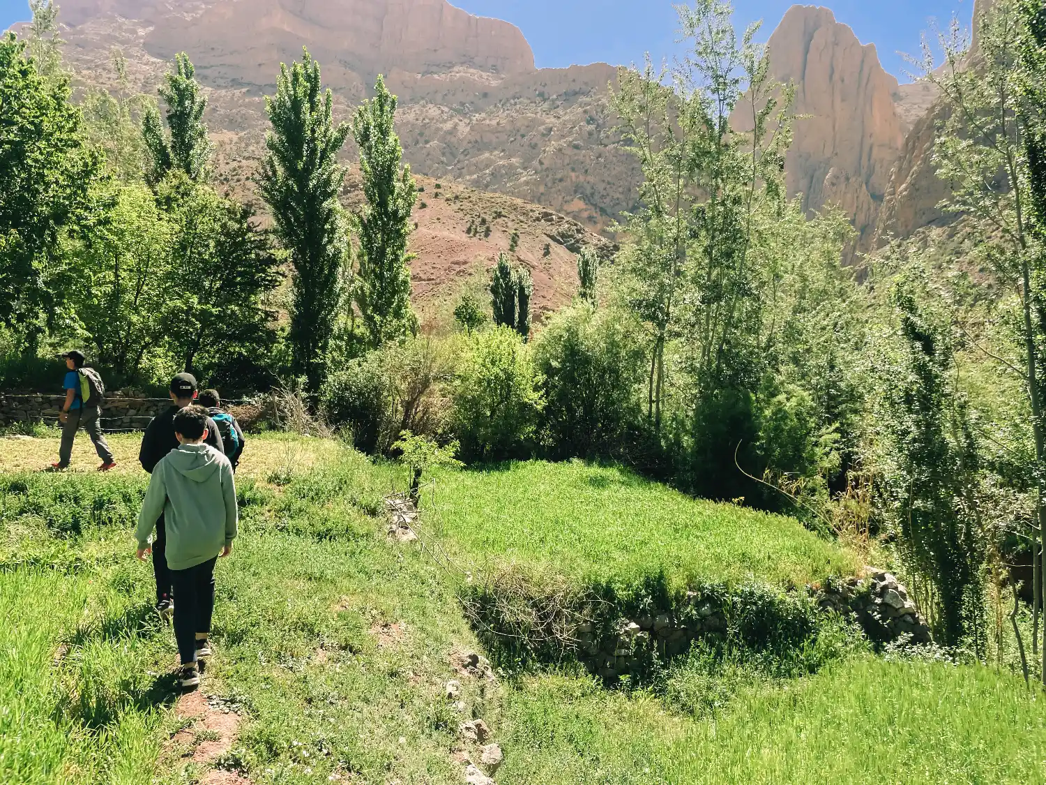 Marcheurs traversant la vallée verdoyante des Aït Bougmez, randonnée douce et immersion nature autour de Touda Ecolodge