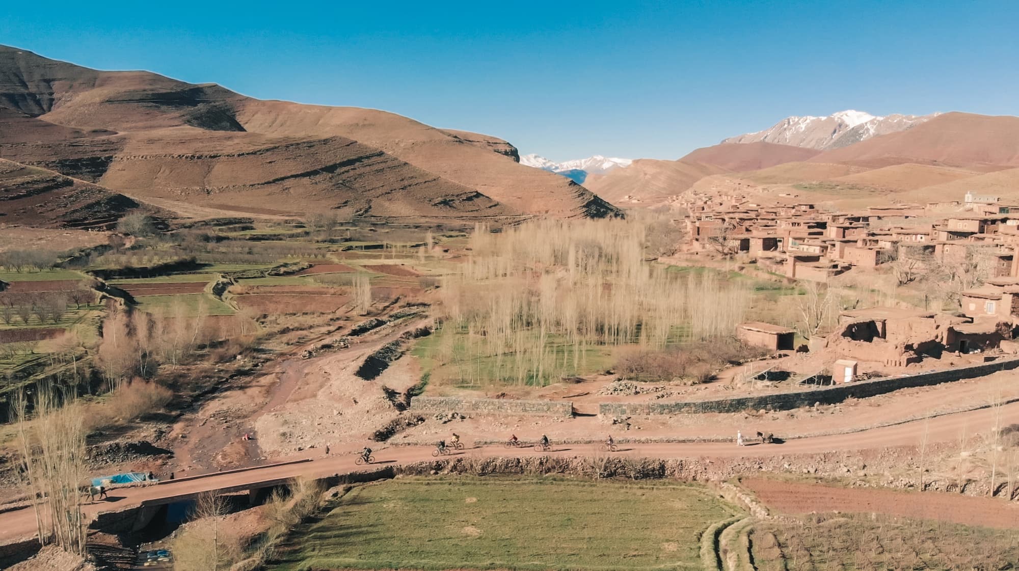 VTT traversant un village berbère dans la vallée des Aït Bougmez, séjour slow travel et écotourisme à Touda Ecolodge