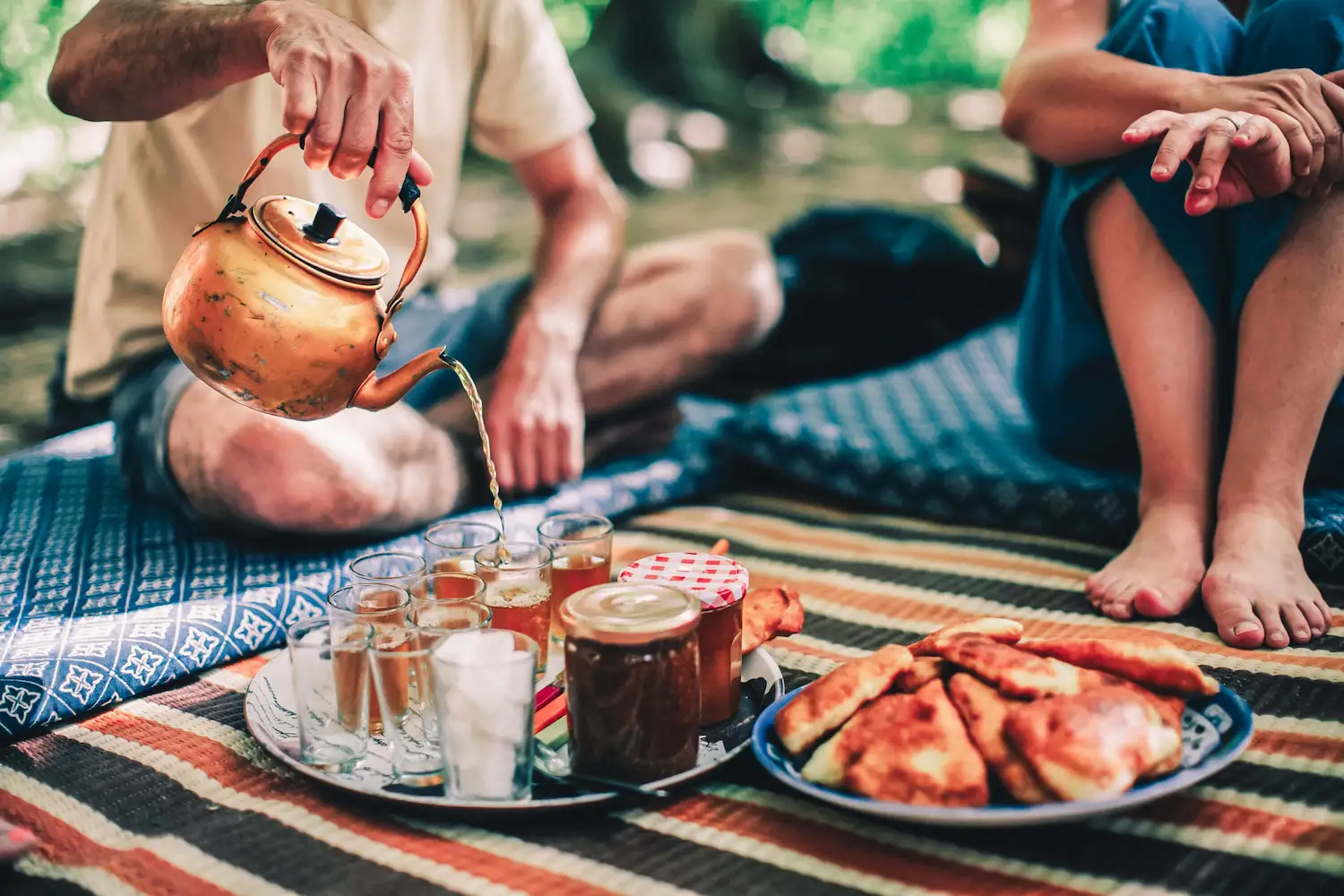 Thé marocain servi sur un tapis traditionnel avec pâtisseries berbères, moment de partage et d’hospitalité à Touda Ecolodge
