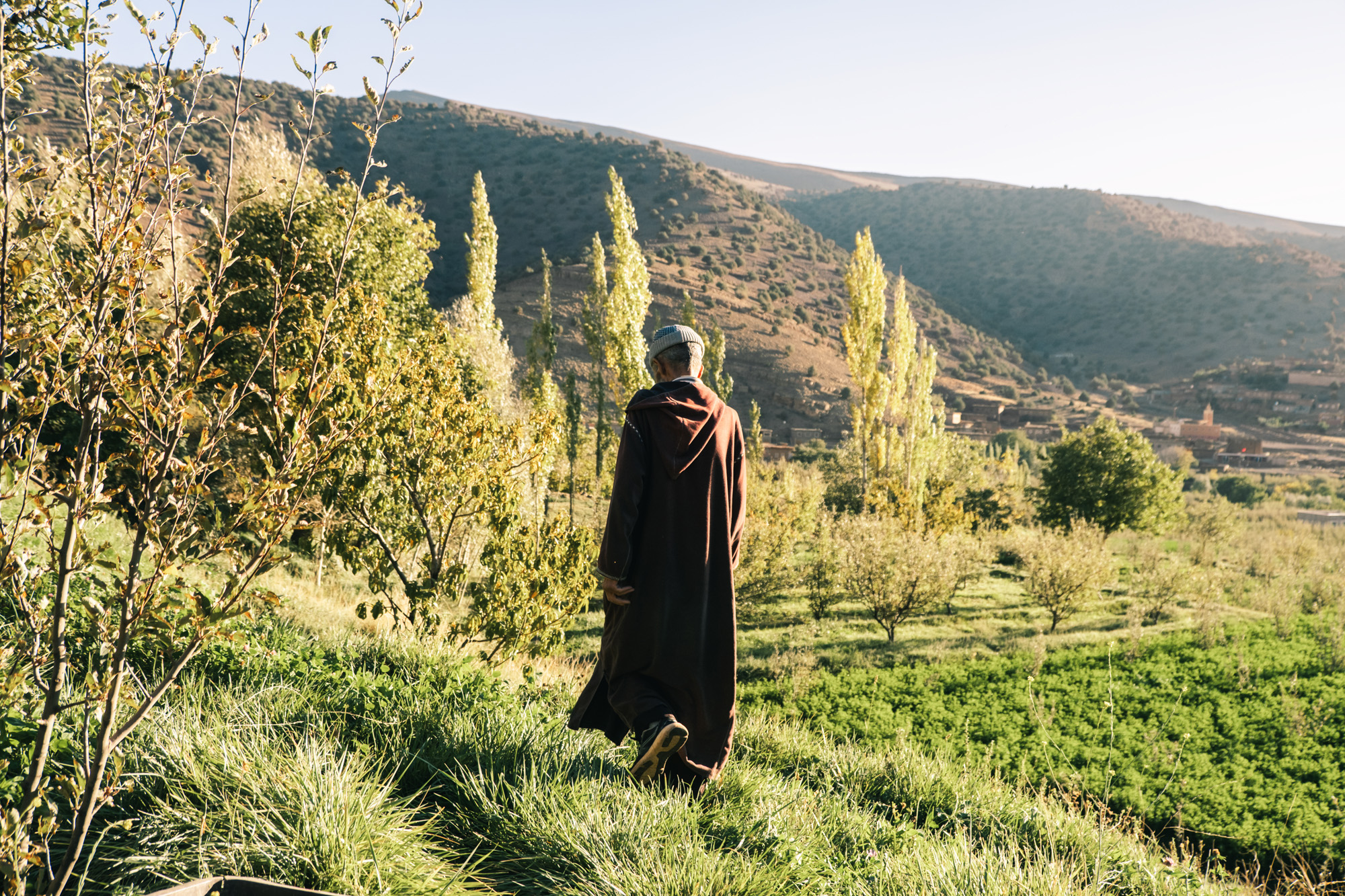 Personne dans une longue cape contemplant la vallée des Aït Bougmez dans l'Atlas marocain