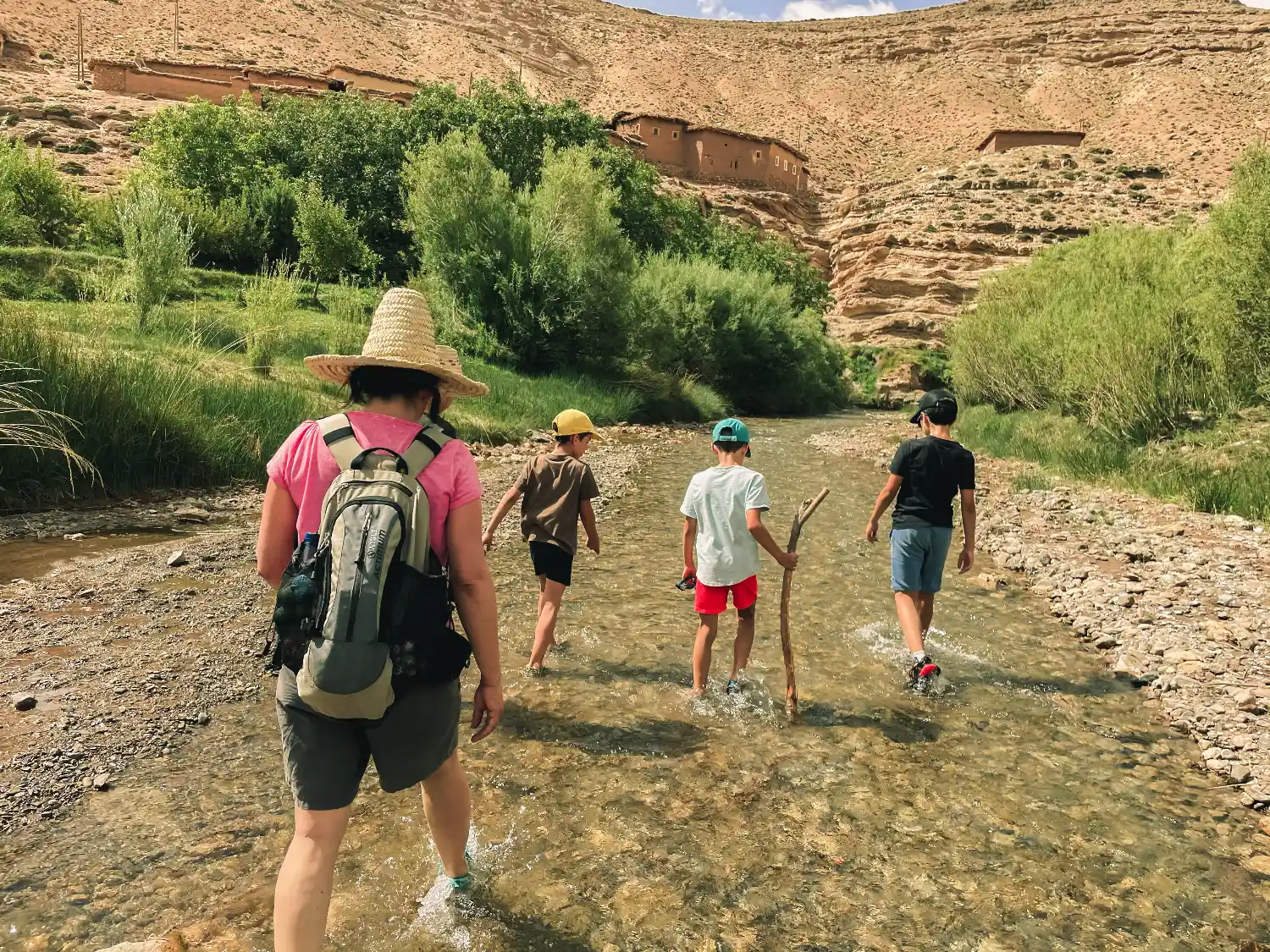 Randonneurs traversant un ruisseau dans la vallée des Aït Bougmez, Haut Atlas marocain