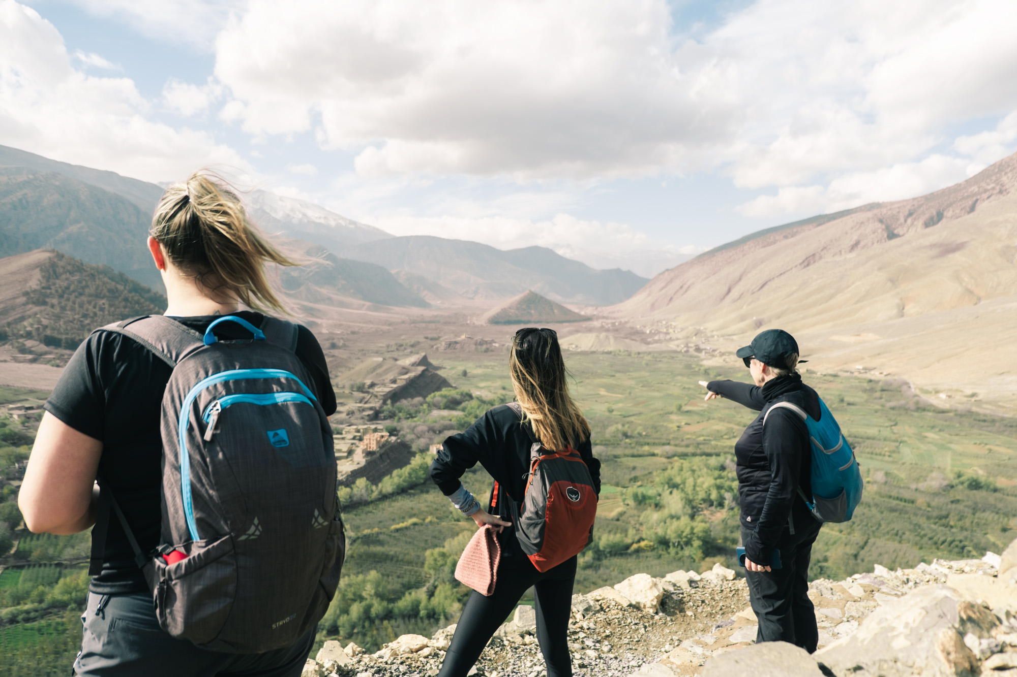 Trois randonneurs contemplant la vallée verdoyante du Haut Atlas marocain