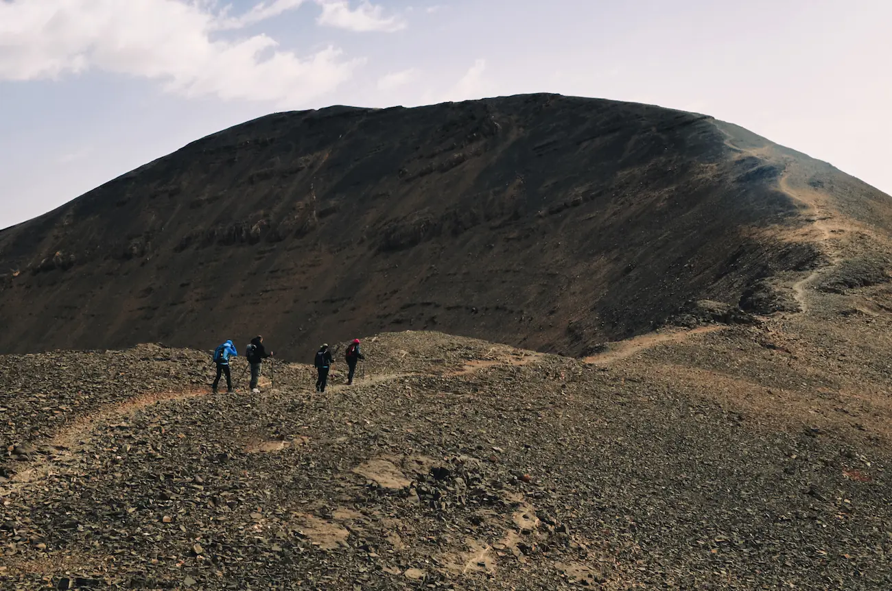 Group of trekkers walking along a high rocky mountain ridge near Mount M'Goun with Touda Ecolodge.