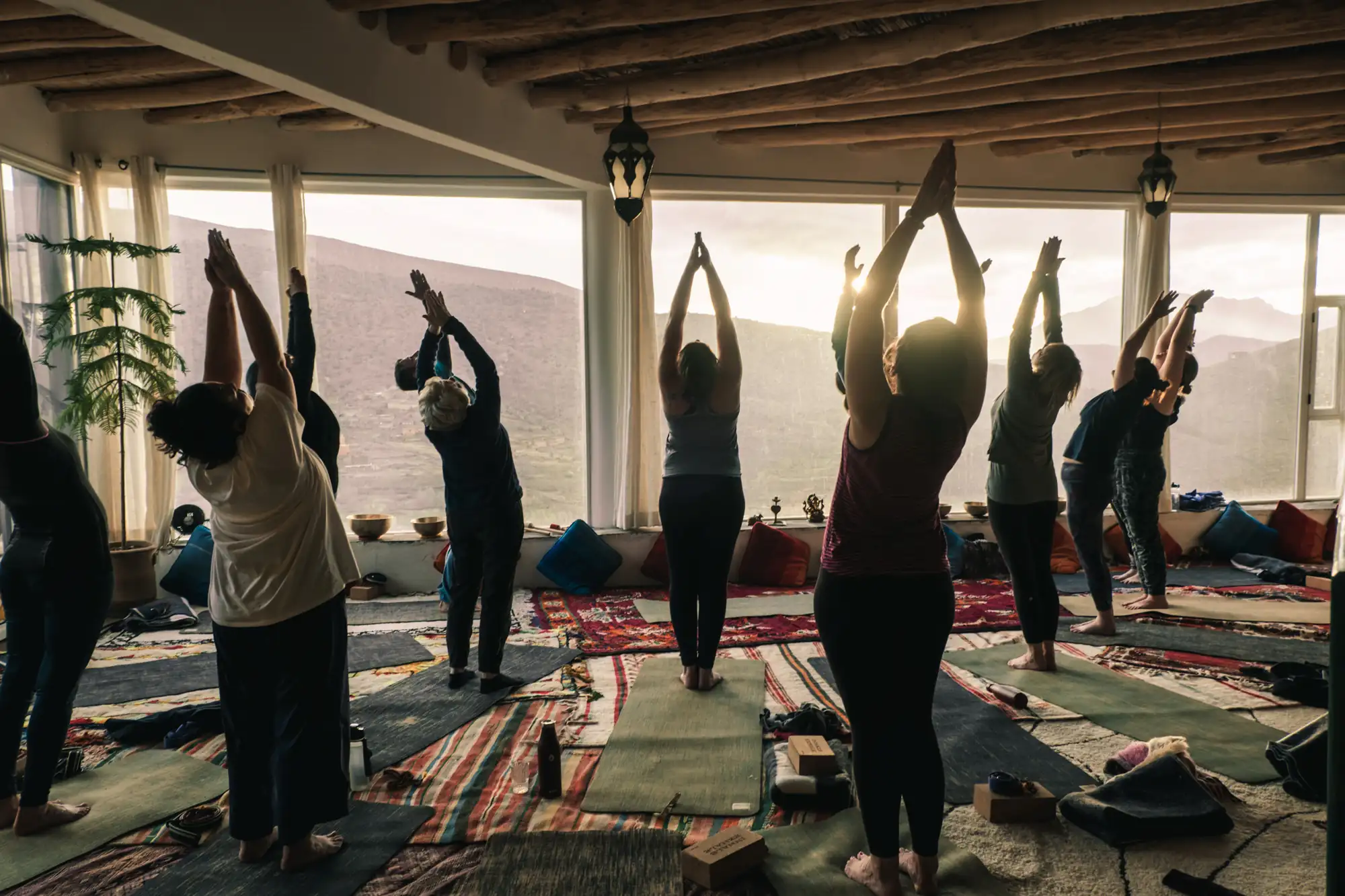 Yoga session in the glass-walled room at Touda Ecolodge, facing the High Atlas mountains