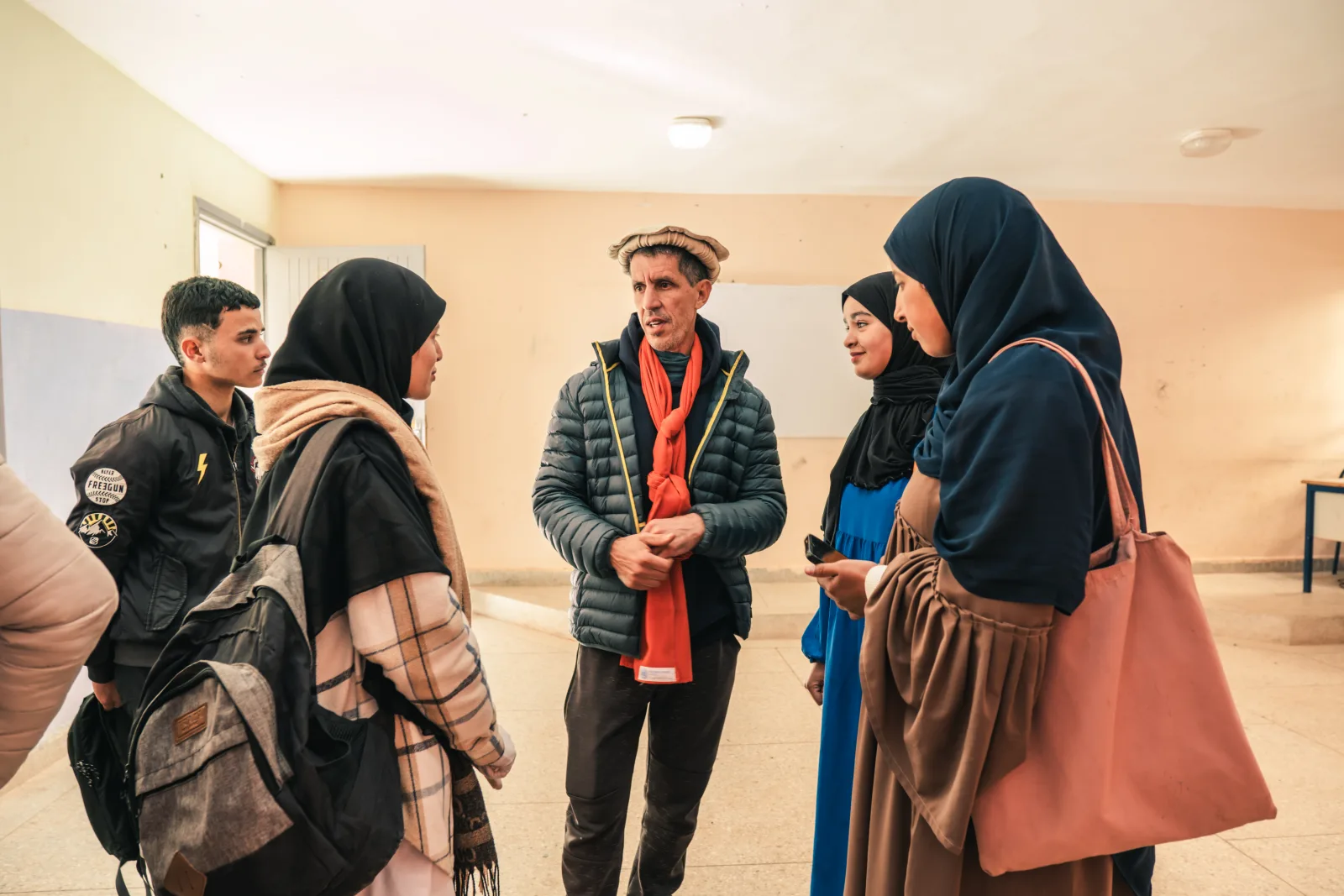 Touda team members talking with local residents in a community hall in the valley